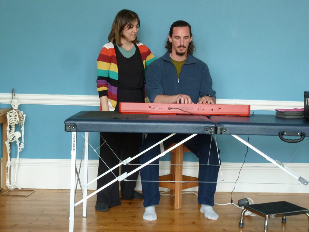 Alexander teacher Eleni helping trainee with his piano playing