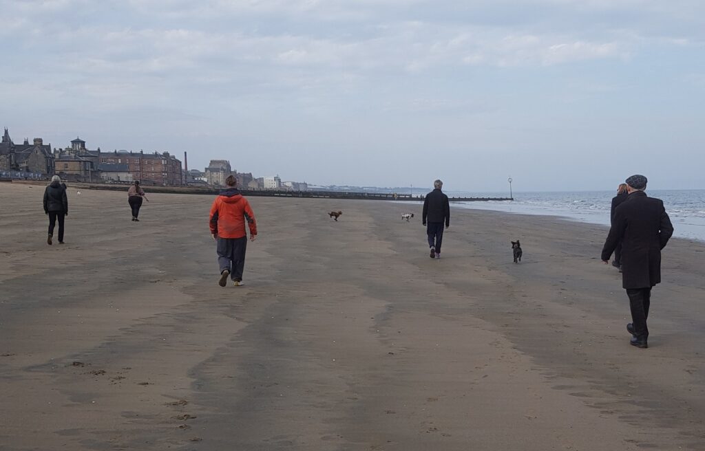 Photo of people walking on Portobello beach exploring the effect of using Alexander Technique thoughts