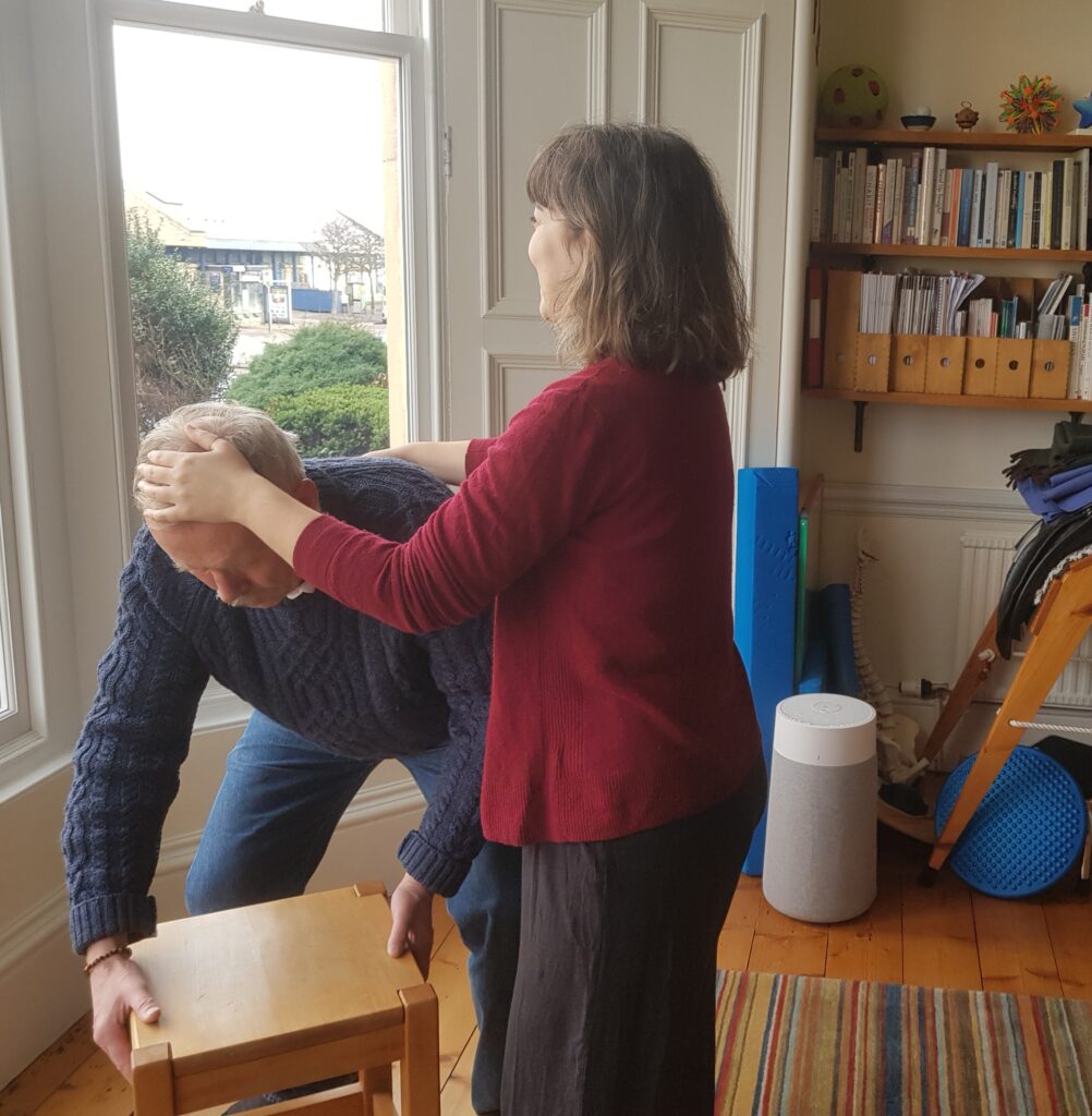 Photo of Alexander teacher, Eleni at Edinburgh Alexander Training School working with a trainee on how to lift with ease