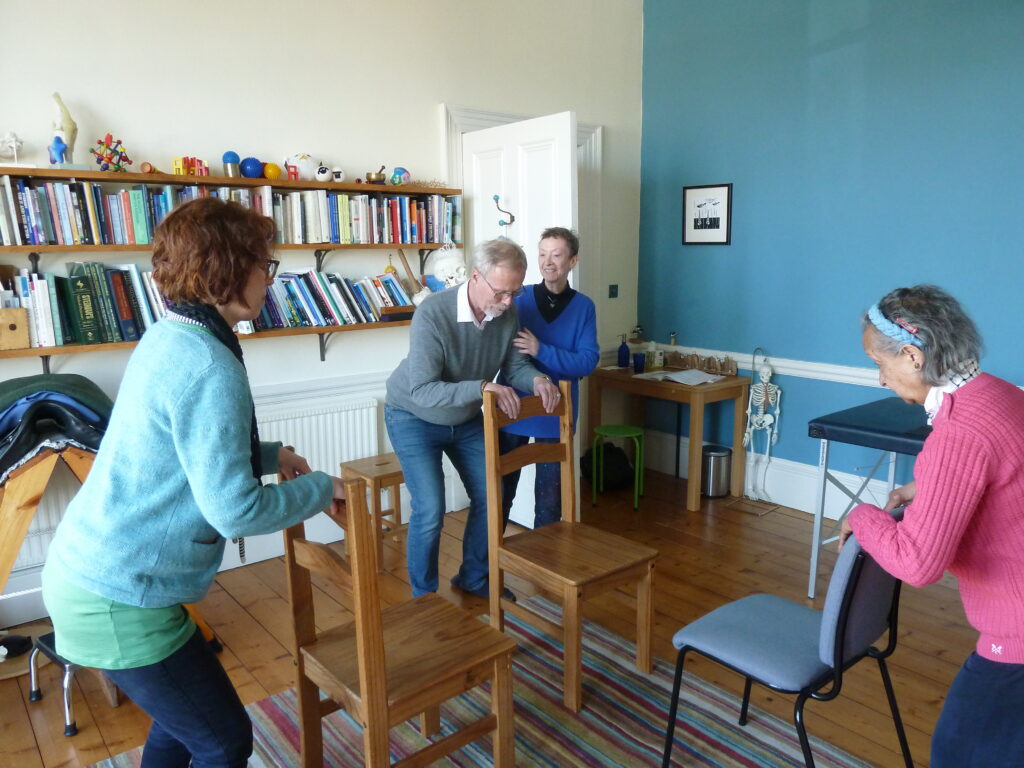 Photo of Alexander teacher, Sandra at Edinburgh Alexander Training School working with trainees on how to fold and hold