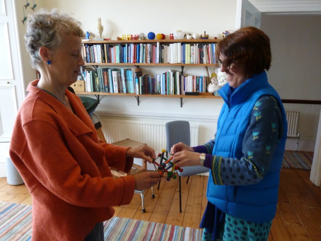 Photo of two people at Edinburgh Alexander Training School holding a tensegrity model between them